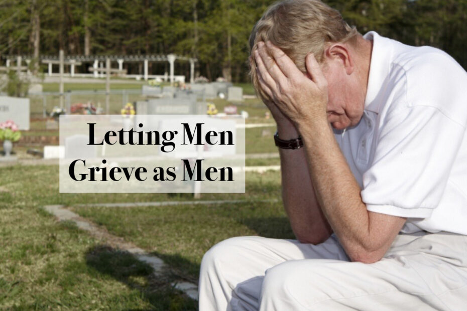 A man holds his head in his hands at a cemetary